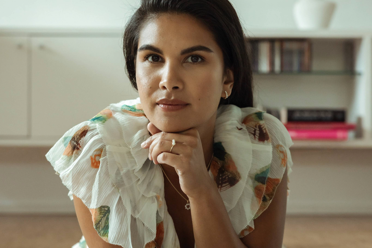 A woman in a floral dress with pearl jewelry